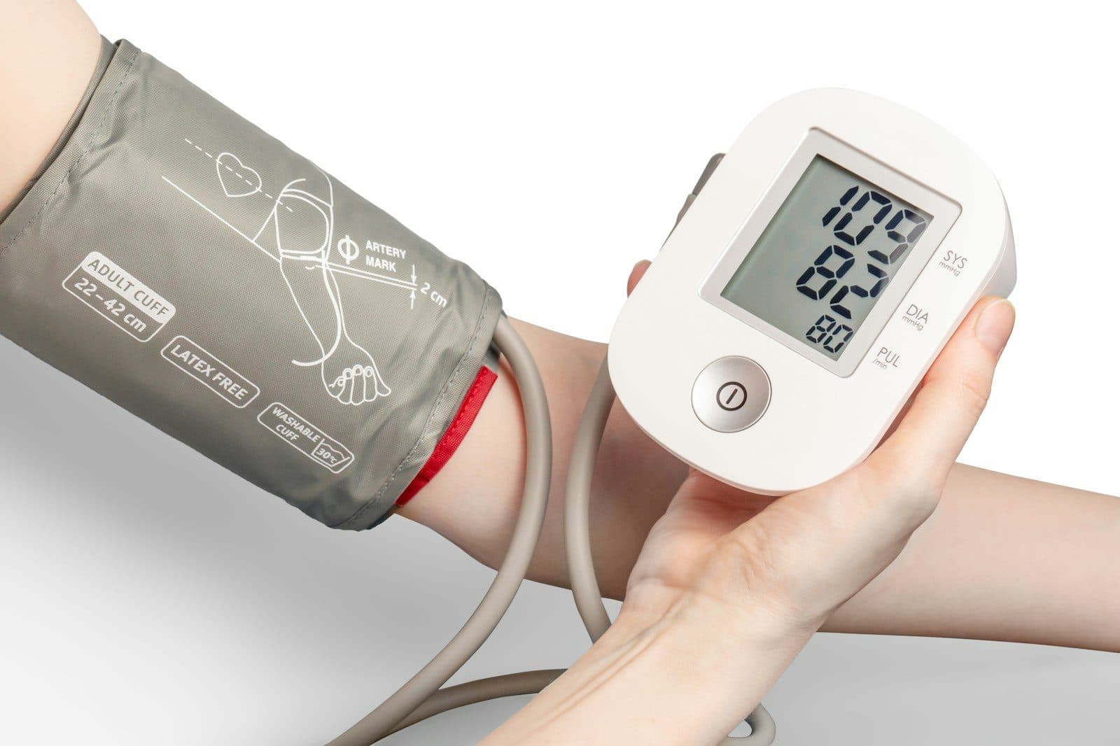 A digital blood pressure monitor with the cuff on a person's upper arm