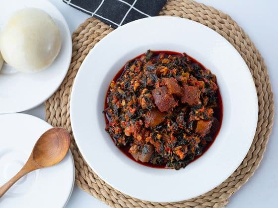 A plate of vegetable soup with swallow on the side